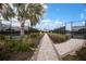 A brick walkway with lush vegetation leads up to a tennis court with black fencing at 3023 Vittorio Ct, Lakewood Ranch, FL 34211