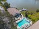 Aerial view of the pool, clubhouse, dock, and lake on a sunny day with palm trees at 3050 Lake Bayshore Dr # O-108, Bradenton, FL 34205