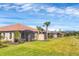 Back exterior of the house, with a screened-in patio overlooking a beautiful lawn and pond at 3105 Formia Ct, Bradenton, FL 34211