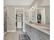 Bathroom featuring dual sinks, quartz countertop, and a door leading to the walk-in closet at 3105 Formia Ct, Bradenton, FL 34211