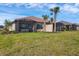 Back exterior featuring screened in patio, beautiful landscaping, and an expansive lawn at 3105 Formia Ct, Bradenton, FL 34211