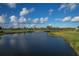 Scenic golf course view featuring a water hazard, lush greenery, and clear blue skies at 3105 Formia Ct, Bradenton, FL 34211