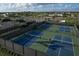 Aerial view of tennis and pickleball courts with shade structures, landscaping, and fencing at 3105 Formia Ct, Bradenton, FL 34211