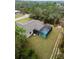 Aerial view of the home showcasing the screened-in pool, backyard, and surrounding wooded area at 336 Milford St, Port Charlotte, FL 33953