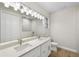 Bright bathroom featuring double sinks with quartz counters and a large mirror reflecting a tiled walk-in shower at 336 Milford St, Port Charlotte, FL 33953