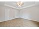 Bright bedroom with wood-look tile, a tray ceiling with fan, and three closets for ample storage at 336 Milford St, Port Charlotte, FL 33953