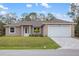 Charming single-story home with a well-manicured lawn, neutral tones, and a two-car garage at 336 Milford St, Port Charlotte, FL 33953