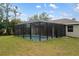 Backyard view of the screened-in pool and green lawn, perfect for Gathering fun and outdoor activities at 336 Milford St, Port Charlotte, FL 33953