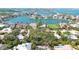 An aerial view highlights a waterfront property surrounded by vibrant green foliage at 3705 Tangier Ter, Sarasota, FL 34239