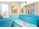 Classic bathroom with blue tiled countertop and walls, featuring a large mirror and bright window at 3705 Tangier Ter, Sarasota, FL 34239