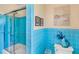 Bright blue tiled bathroom features a glass shower and classic fixtures at 3705 Tangier Ter, Sarasota, FL 34239