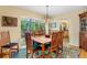 Elegant dining room with a wooden table and chairs, cabinet, and a serene view of the outdoor greenery at 3705 Tangier Ter, Sarasota, FL 34239