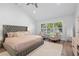 Bright bedroom featuring a large tufted bed, two chairs, a window with plantation shutters, and hardwood floors with rug at 3759 Beneva Oaks Blvd, Sarasota, FL 34238