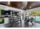 Bright home gym with exposed-beam ceiling featuring modern workout equipment with pool views at 3759 Beneva Oaks Blvd, Sarasota, FL 34238