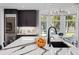 Kitchen island with white and grey marble and breakfast bar seating, plus modern appliances and a sink at 3759 Beneva Oaks Blvd, Sarasota, FL 34238