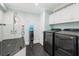 Well-equipped laundry room featuring a shower, utility sink, and modern washer and dryer at 3759 Beneva Oaks Blvd, Sarasota, FL 34238