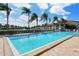 Inviting community pool surrounded by palm trees and patio furniture at 4147 Marseilles Ave # 3068, Sarasota, FL 34233