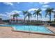 Community pool area with surrounding palm trees and patio furniture at 4147 Marseilles Ave # 3068, Sarasota, FL 34233