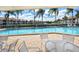 Community pool with plenty of lounge chairs and patio tables at 4147 Marseilles Ave # 3068, Sarasota, FL 34233