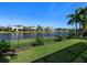 Lush backyard with a serene lake view, featuring a secure fence and a well-maintained lawn at 4617 Garden Arbor Way, Bradenton, FL 34203