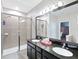 Bathroom with dual sinks, granite countertop, tiled shower, and a large mirror reflecting the adjacent space at 4617 Garden Arbor Way, Bradenton, FL 34203