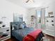 Modern bedroom featuring a gray bed, a red throw, white shelving, and a bright window at 4617 Garden Arbor Way, Bradenton, FL 34203