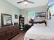 Comfortable bedroom with a ceiling fan, dresser, and a well-lit window, creating a relaxing atmosphere at 4617 Garden Arbor Way, Bradenton, FL 34203