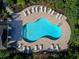 Overhead view of community pool, surrounded by brick patio and lounge chairs, bordered by lush landscaping at 4617 Garden Arbor Way, Bradenton, FL 34203