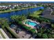 Aerial view of community pool, playground, and lake with manicured landscaping and comfortable lounge chairs at 4617 Garden Arbor Way, Bradenton, FL 34203