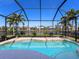 Sparkling pool enclosed with a screened cage, surrounded by lush landscaping and views of the lake at 4617 Garden Arbor Way, Bradenton, FL 34203