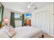 Cozy bedroom features a ceiling fan, TV, closet, and a bright window with green curtain accents at 494 E Shade Dr, Venice, FL 34293