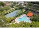 Aerial view showing community pool, gazebo, and tennis court surrounded by lush landscaping and homes at 4969 Creekside Trl, Sarasota, FL 34243