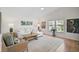 Bright living room with white sofa, wood flooring, and large windows with outside view at 4969 Creekside Trl, Sarasota, FL 34243