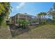 Screened in pool with palm trees and verdant landscaping in backyard at 4969 Creekside Trl, Sarasota, FL 34243