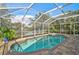 Enclosed pool area with clear blue water, brick decking, and scenic views of the surrounding landscape at 4969 Creekside Trl, Sarasota, FL 34243