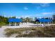 Beach view of two blue beach canopies offering shade, with white sand and lush greenery in the background at 500 Harbor Point Rd, Longboat Key, FL 34228