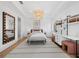 Bright bedroom features a decorative chandelier, chic decor, and a large mirror for a stylish and inviting space at 500 Harbor Point Rd, Longboat Key, FL 34228