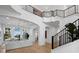 Bright foyer featuring a grand staircase, modern railings, and a view of the living area at 500 Harbor Point Rd, Longboat Key, FL 34228