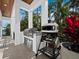 Outdoor kitchen with grill and pizza oven nestled among tropical foliage at 500 Harbor Point Rd, Longboat Key, FL 34228