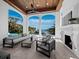 Beautiful outdoor living area with fireplace, ceiling fan, and stunning water views at 500 Harbor Point Rd, Longboat Key, FL 34228