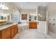 This primary bathroom features double sinks, a soaking tub, glass block window, and walk-in shower at 5155 Cantabria Crest, Sarasota, FL 34238