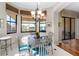 Bright dining area with a chandelier and views of the fountain and landscaping outside at 5155 Cantabria Crest, Sarasota, FL 34238