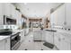 Bright kitchen featuring white cabinets, stainless steel appliances, and views of the backyard at 5155 Cantabria Crest, Sarasota, FL 34238