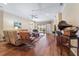 Cozy living room featuring hardwood floors, comfortable seating, a ceiling fan, and access to the screened patio at 5155 Cantabria Crest, Sarasota, FL 34238