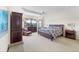 This main bedroom features neutral carpeting, a ceiling fan, water view, and woven furniture at 5155 Cantabria Crest, Sarasota, FL 34238