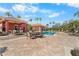 Resort-style pool with brick pavers, lounge chairs, and palm trees under a sunny blue sky at 5155 Cantabria Crest, Sarasota, FL 34238