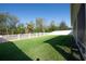 Spacious backyard with a well-maintained lawn and a white fence at 5718 Broad River Run, Ellenton, FL 34222