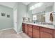 Bathroom boasts a double sink vanity with granite countertops and framed mirrors at 5718 Broad River Run, Ellenton, FL 34222