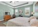 Relaxing main bedroom features a tray ceiling, wood flooring, and natural lighting at 5718 Broad River Run, Ellenton, FL 34222