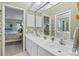 Bathroom featuring double sinks, a large mirror, and a doorway into the main bedroom at 5718 Garden Lakes Palm, Bradenton, FL 34203